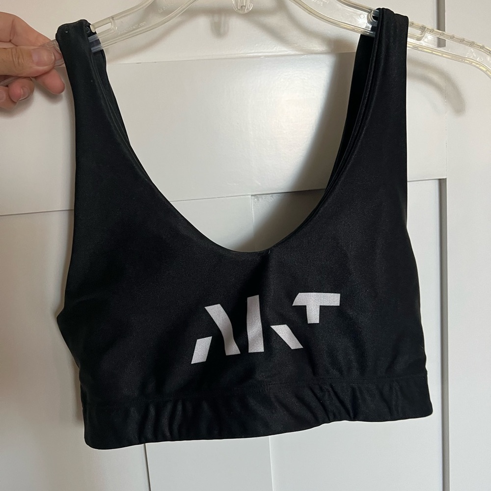 Gold sheep black sports bra with AKT logo. Size medium.